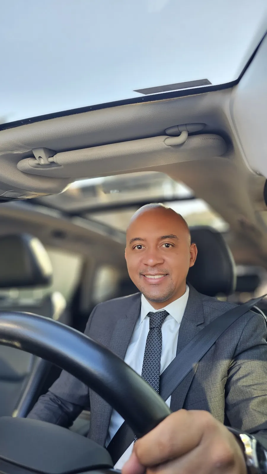 Bruno Inácio, motorista executivo e fundador da Bruno Inácio - Transporte Executivo, de terno ao volante do carro
