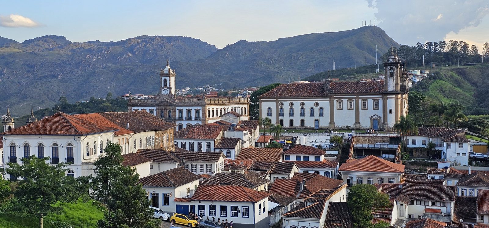 Vista panorâmica do centro histórico de Ouro Preto, com casarões coloniais, igrejas e a serra ao fundo